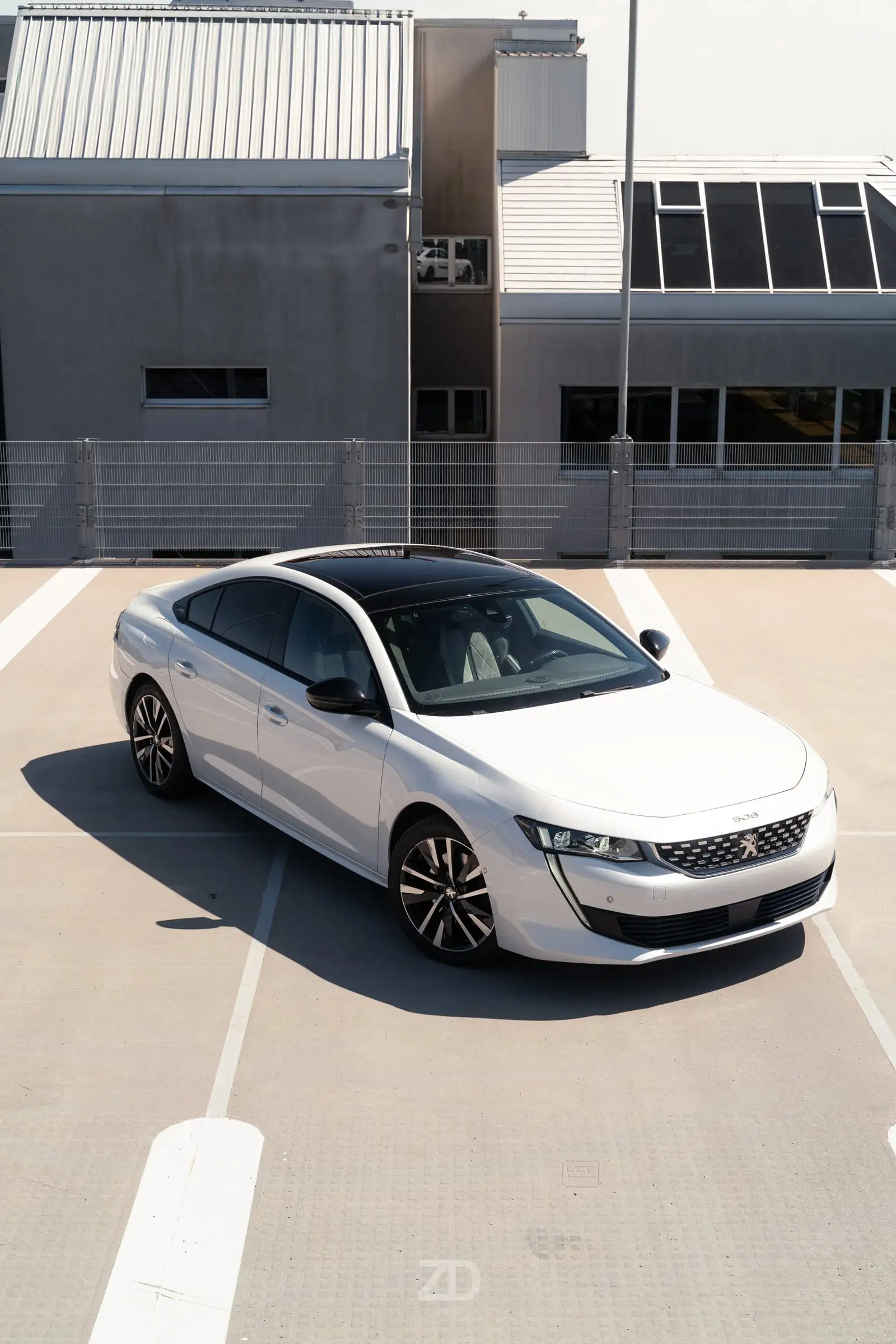 Weiße Limousine von oben auf einem Parkdeck