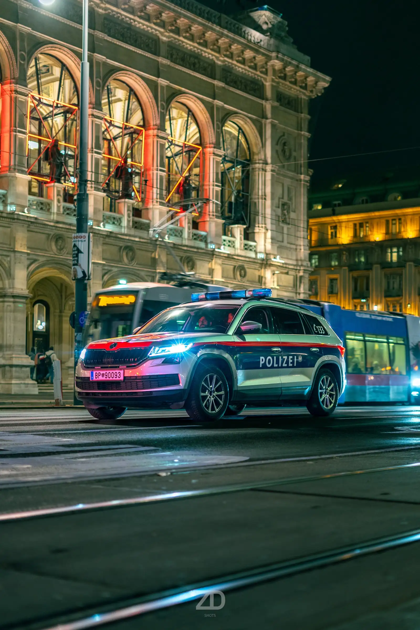 Polizeifahrzeug bei Nacht vor der beleuchteten Staatsoper
