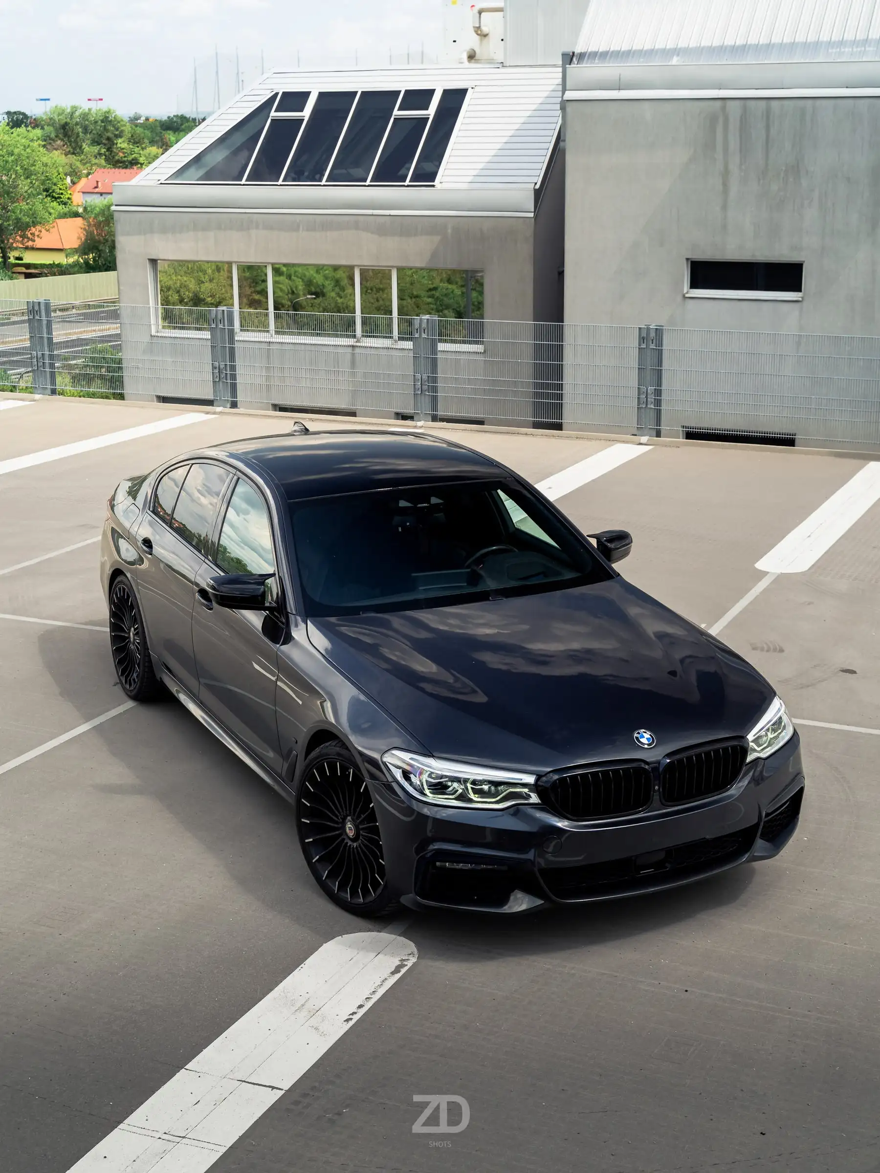 Dunkle Limousine auf einem Parkdeck, von vorne schräg fotografiert