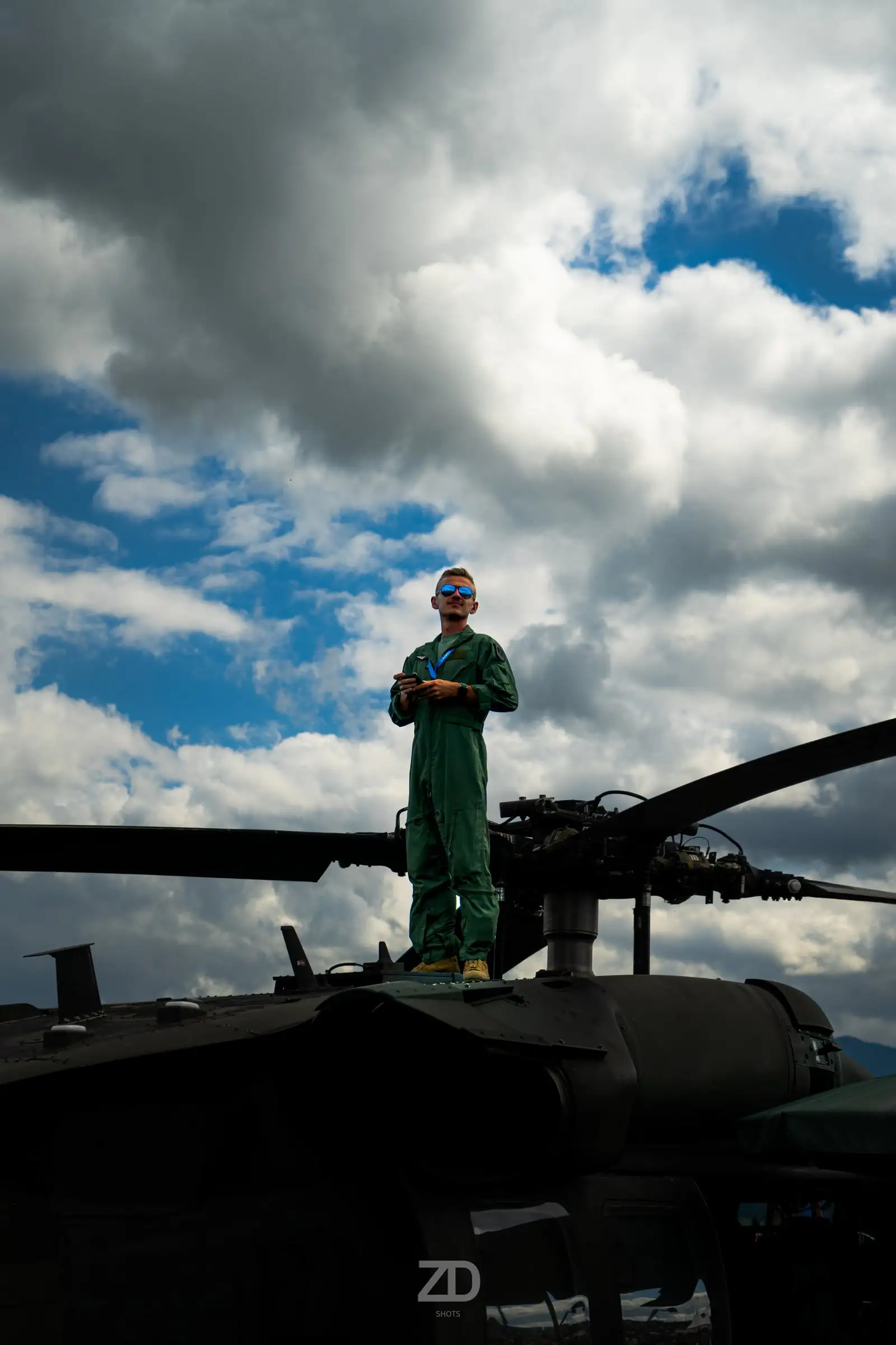 Soldat steht auf einem Hubschrauber vor Wolkenhimmel