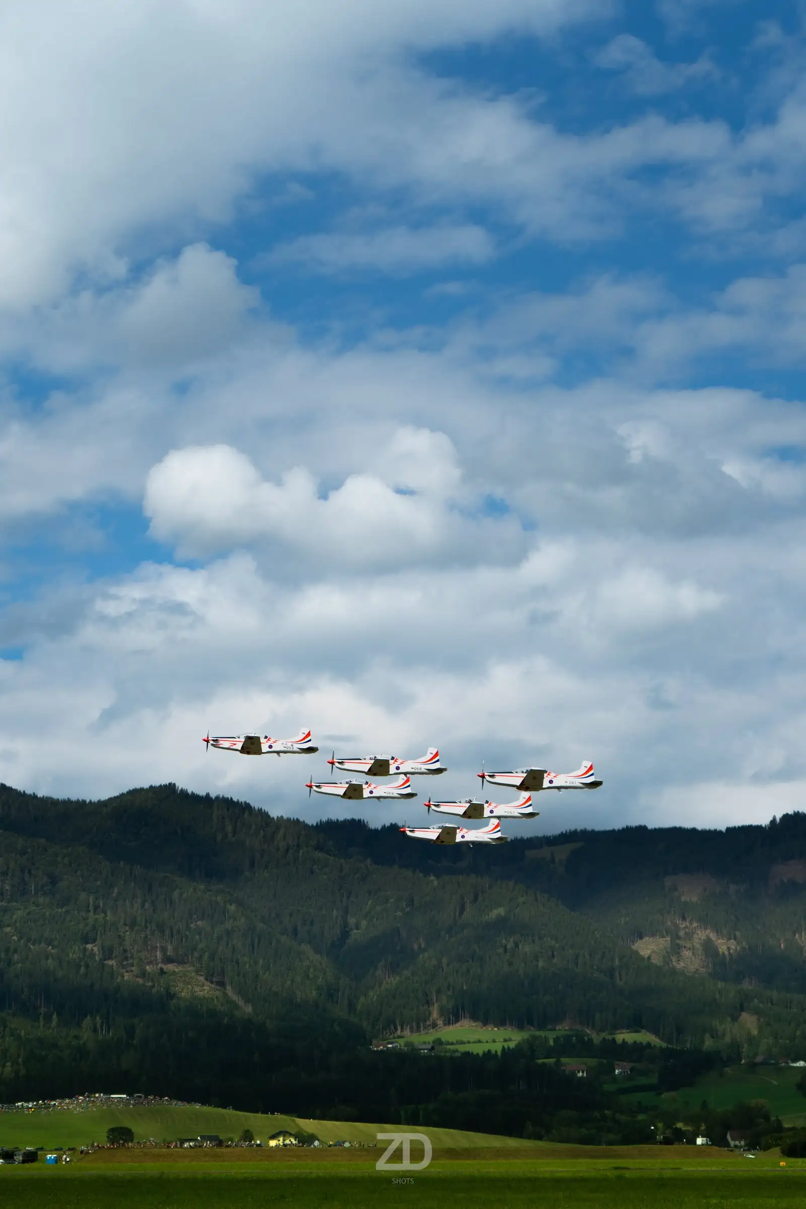 Flugzeugstaffel über grünen Hügeln