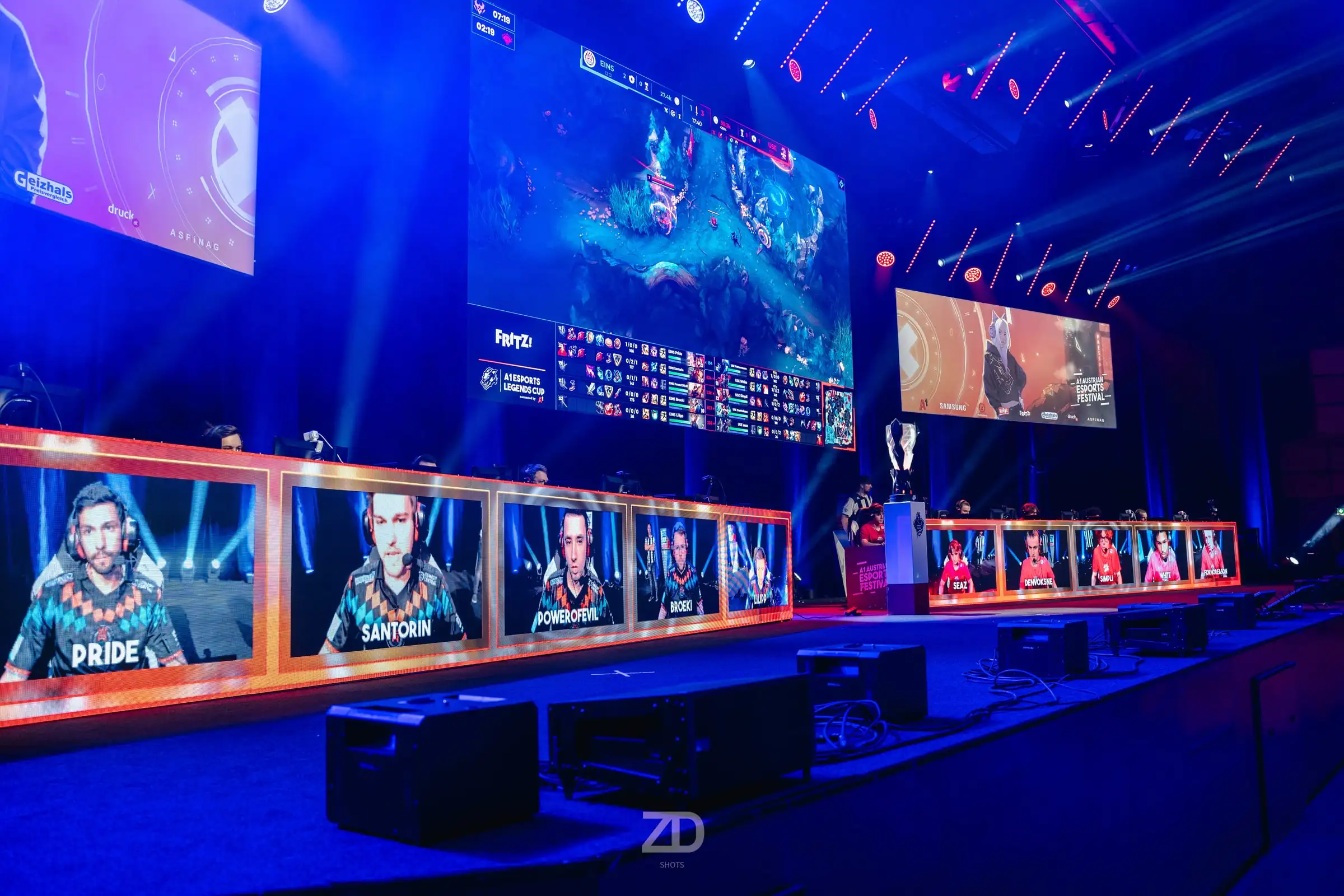 Große Bühne mit Leinwänden und blauem Licht bei einem Gaming-Turnier