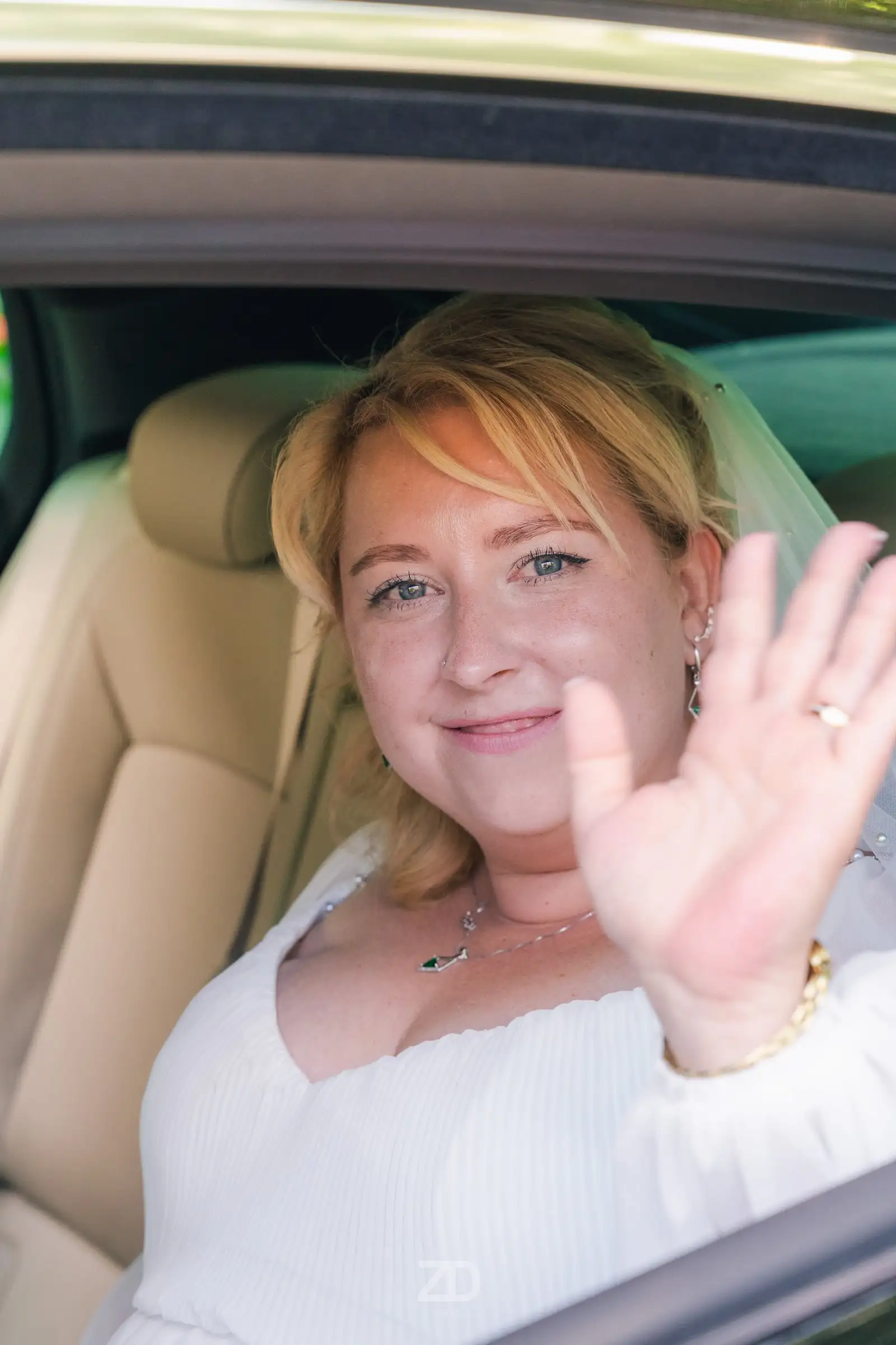 Braut winkt aus dem Autofenster