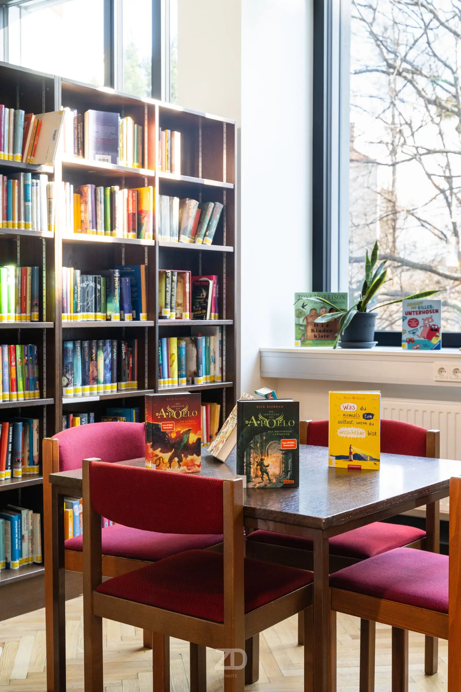 Leseecke mit Bücherregalen und roten Stühlen