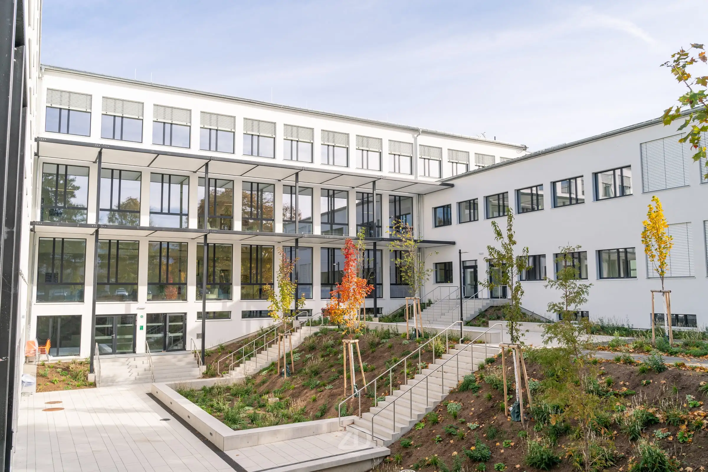 Innenhof eines modernen Schulgebäudes mit Grünflächen