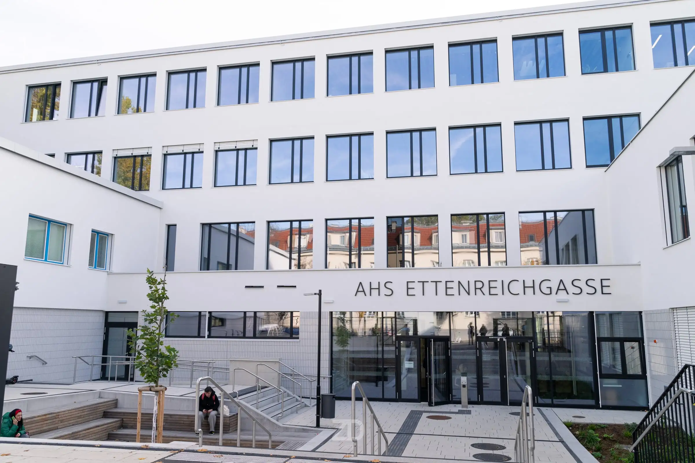 Weiße Fassade eines Schulgebäudes mit Eingangsbereich