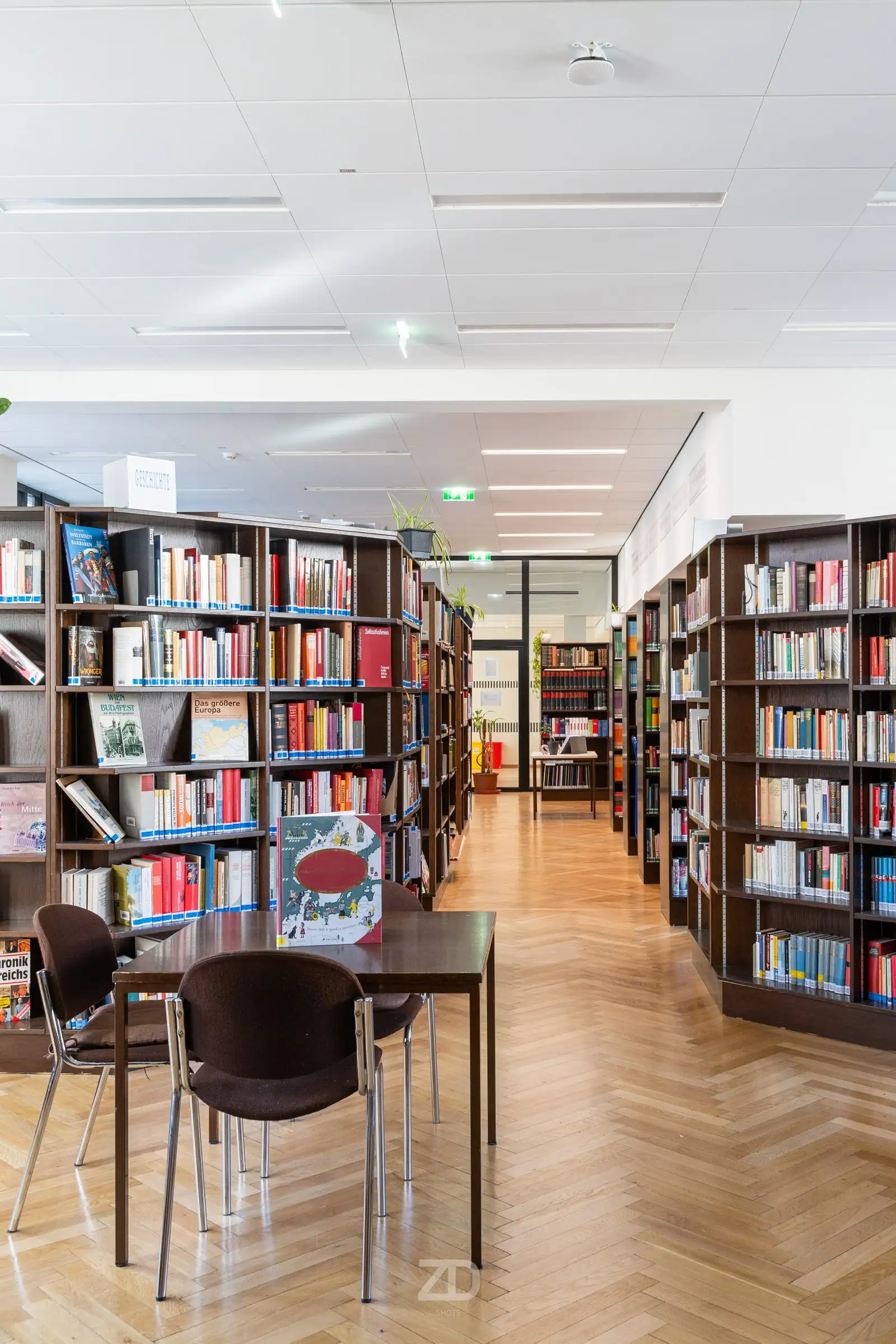 Bibliothek mit Regalen und Tischen