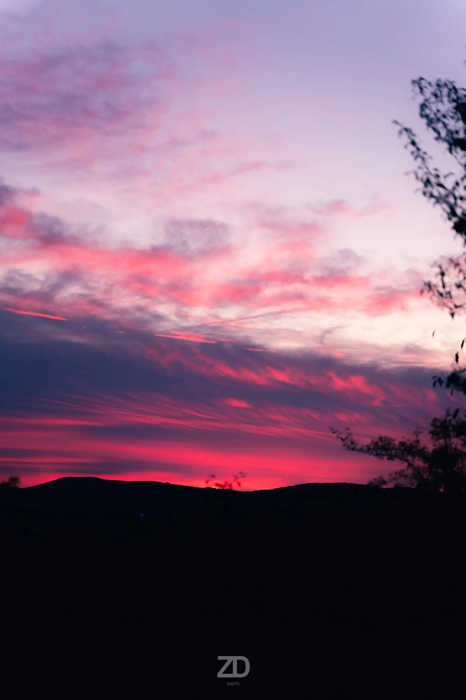 Pinker Abendhimmel über einer dunklen Hügelkette