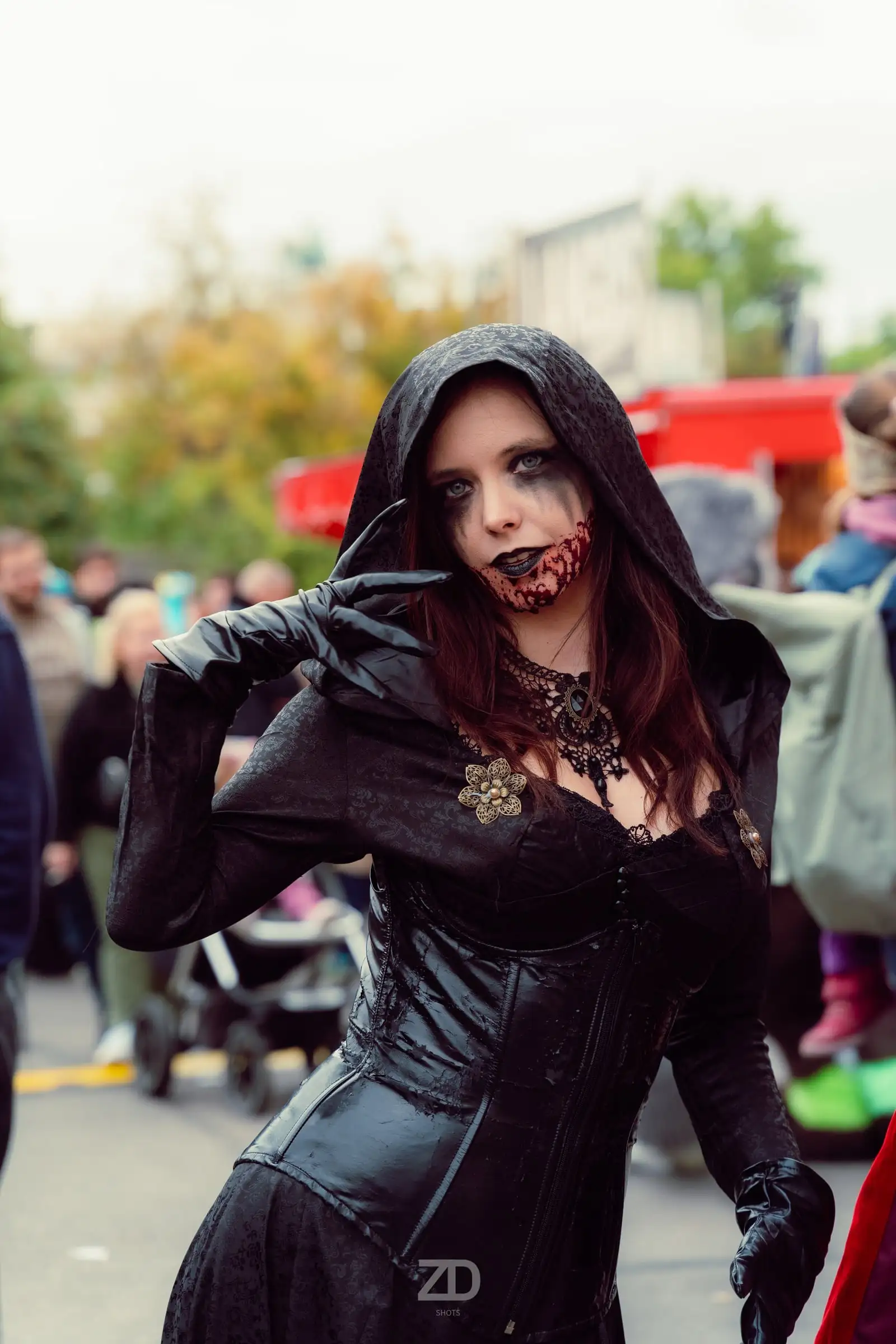 Cosplayerin in dunklem Kapuzenkostüm im Freien
