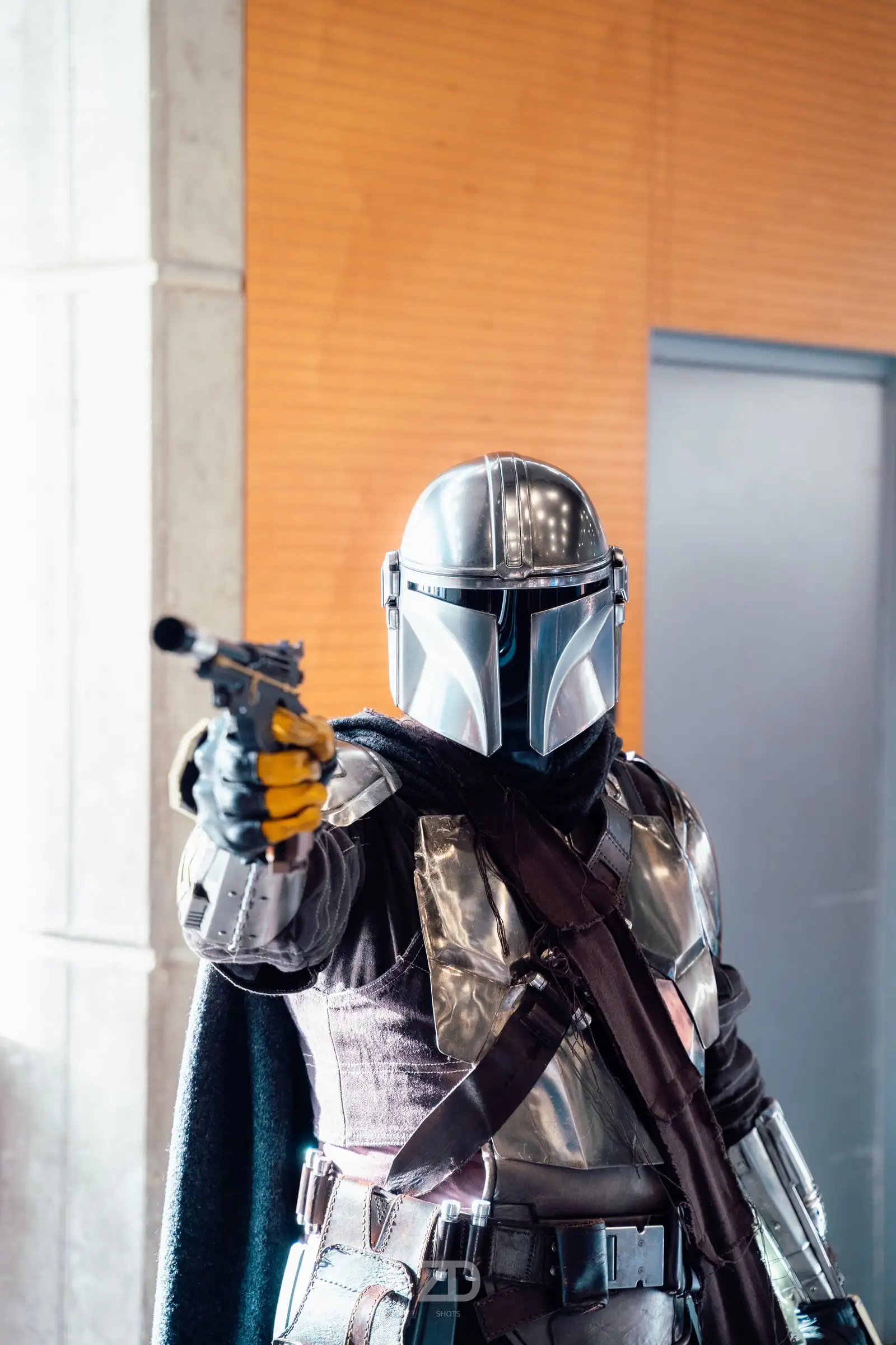 Cosplayer in silberner Rüstung mit Helm zielt zur Seite