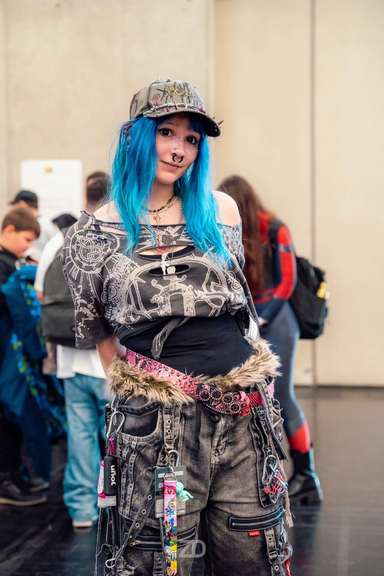 Frau mit blauen Haaren und Kappe in einem Streetwear-Outfit