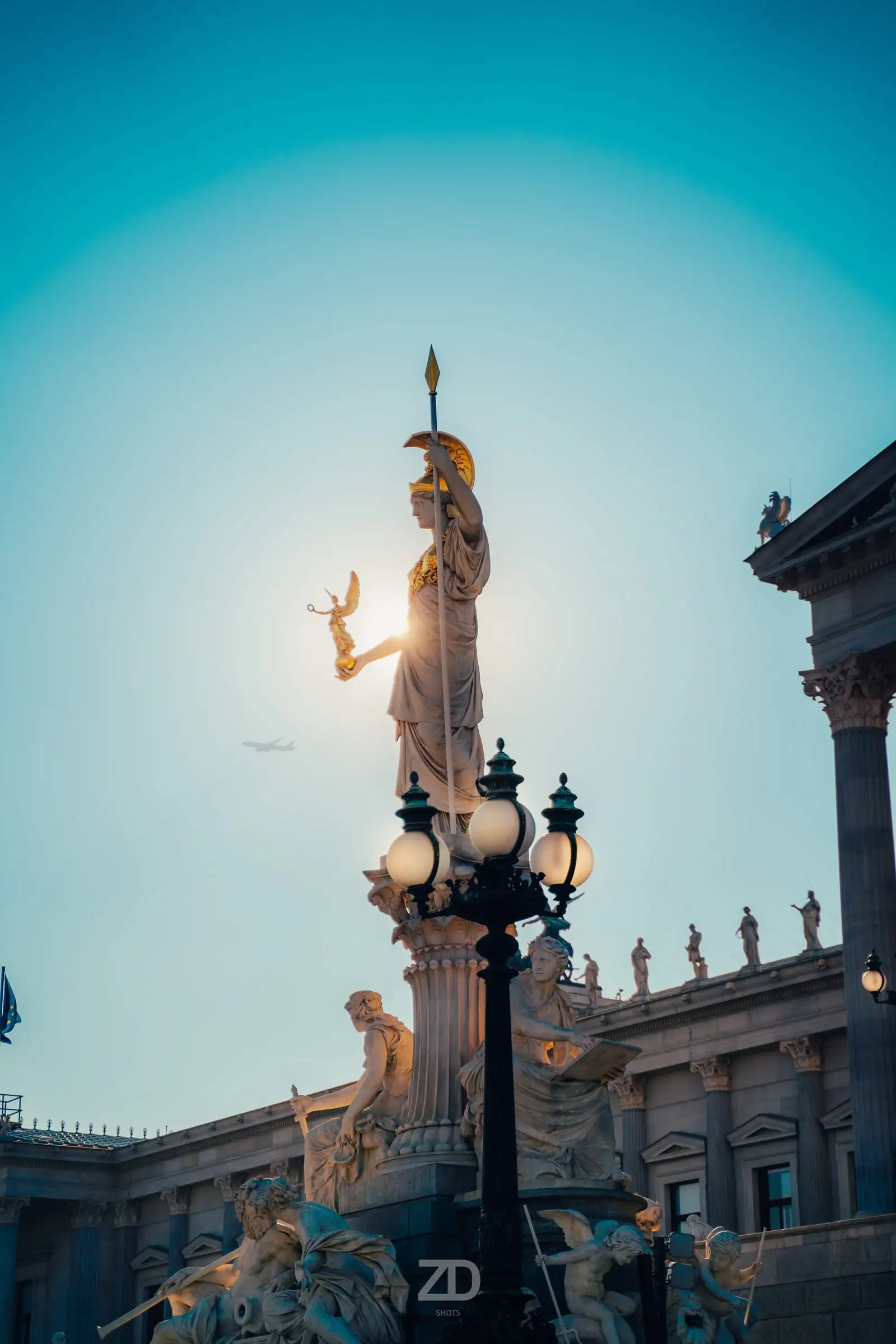 Statue im Gegenlicht vor türkisem Himmel