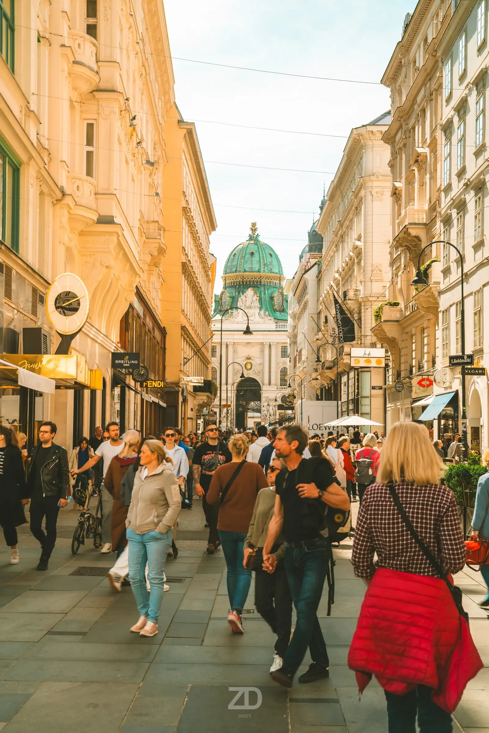 Belebte Einkaufsstraße mit Kuppel im Hintergrund