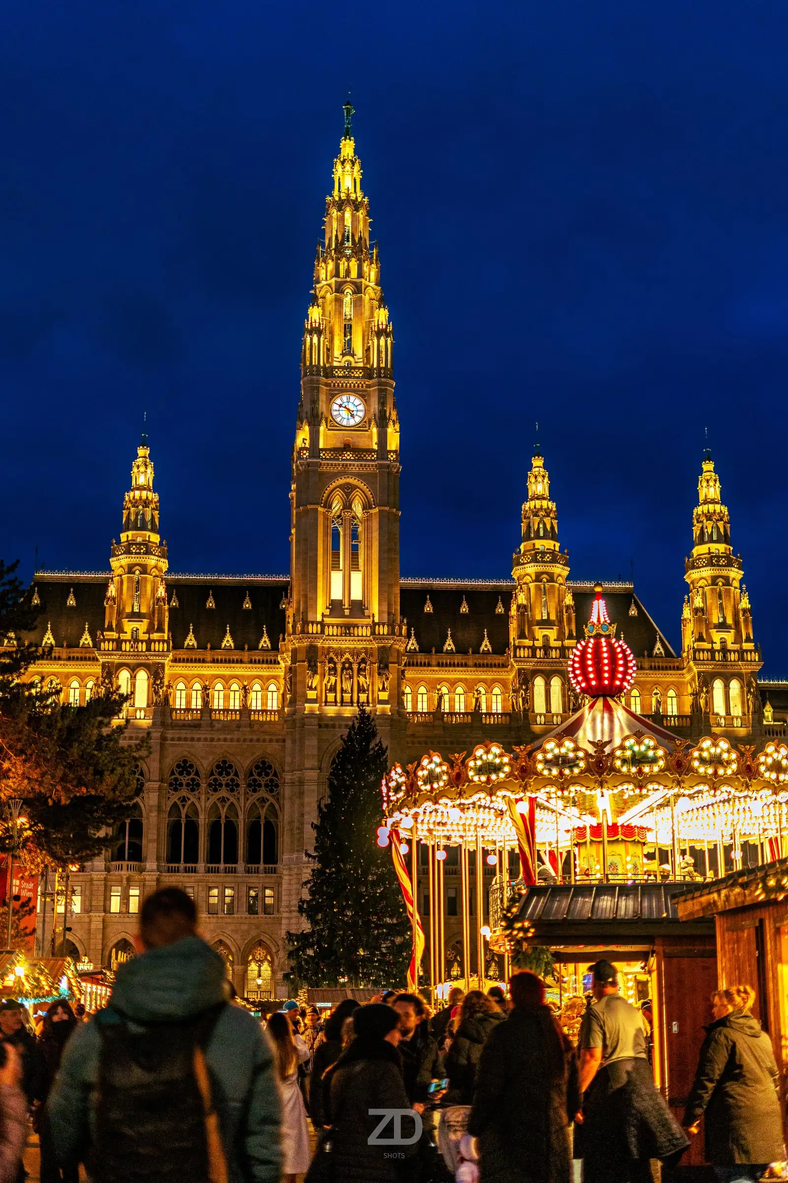 Beleuchtetes Rathaus mit Christkindlmarkt