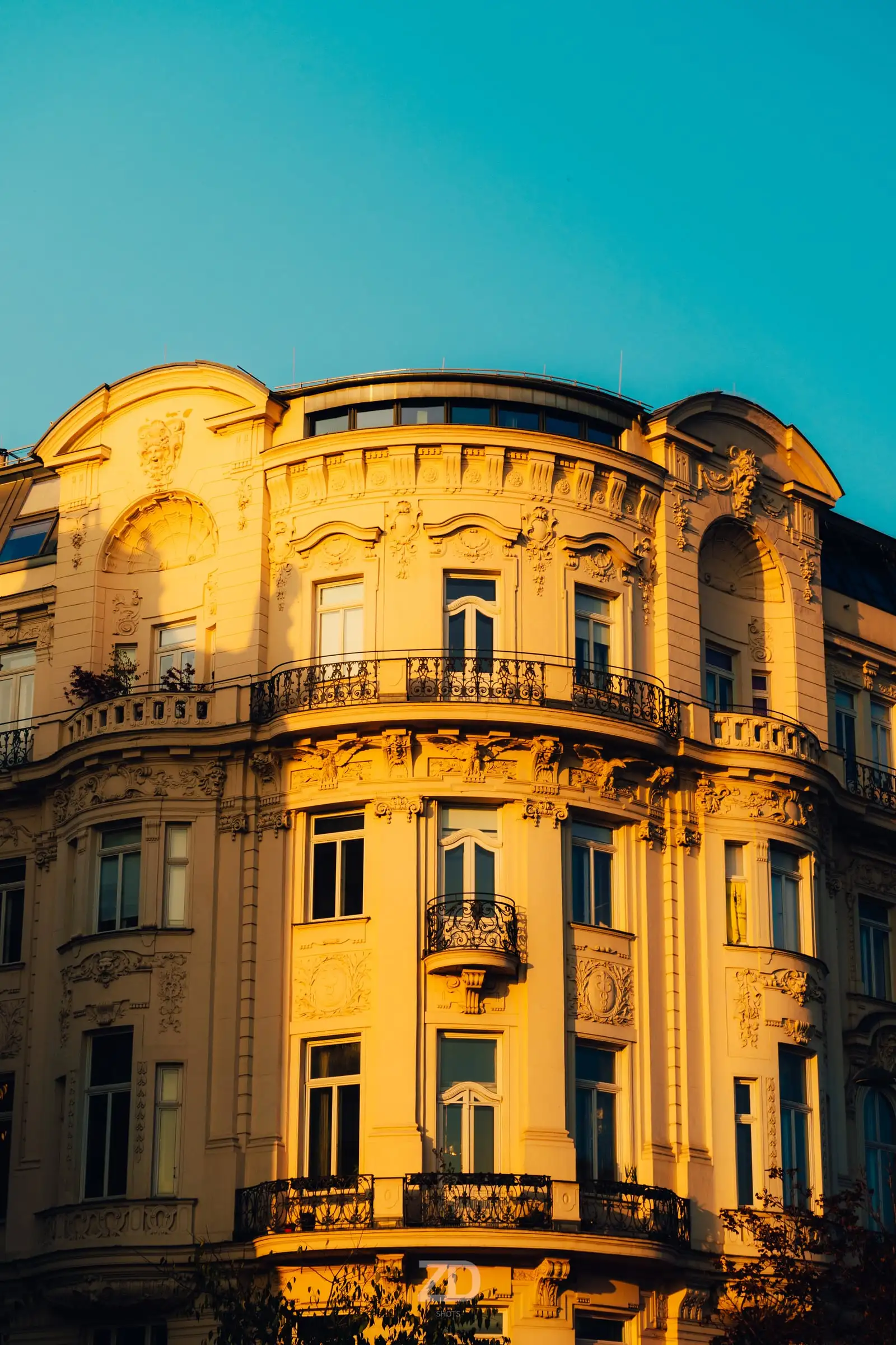 Gelbe Altbaufassade im Abendlicht vor blauem Himmel