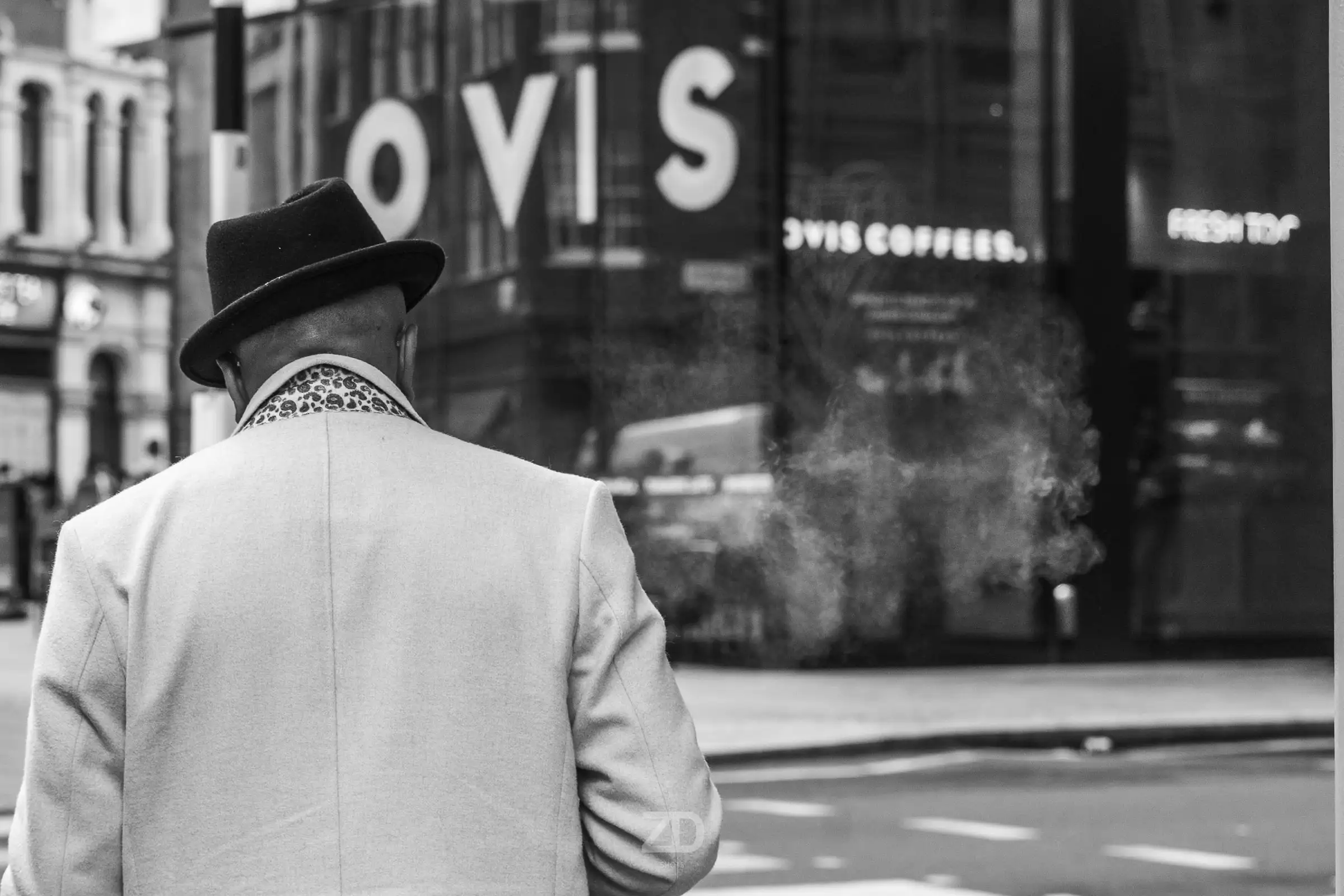 Mann mit Hut von hinten vor einem Schaufenster